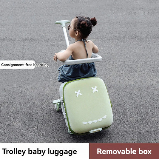 Child sitting on a green trolley baby luggage with a removable box feature.
